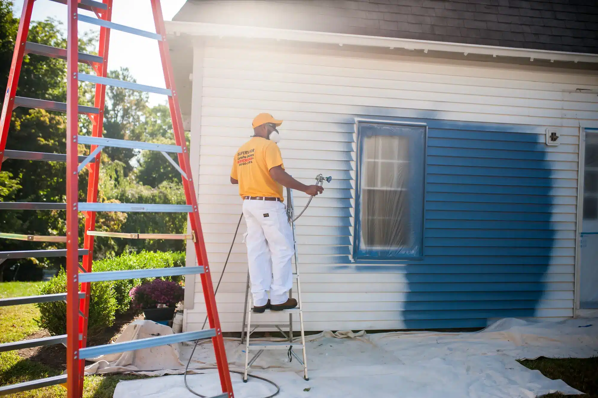 Professional exterior house painting in early spring showing refreshed siding and trim before summer season in Rhode Island