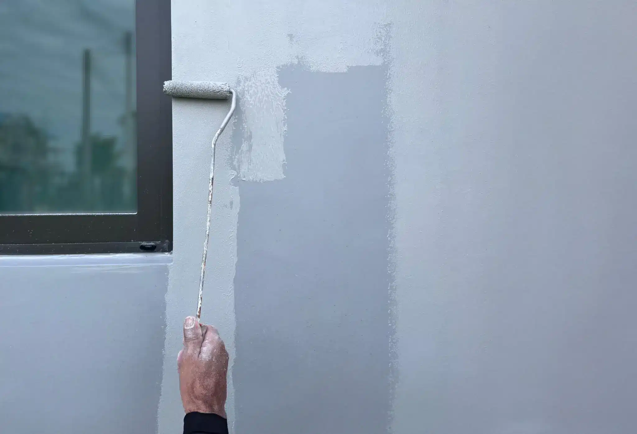 Applying primer to exterior siding before painting to improve adhesion and durability